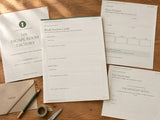 Printed Escape Room Factory Creator Mode station cards, player passport, invitations and planning pages on a wood table with ordinary stationery; printable digital download
