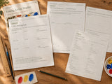 Printed Young Artist Studio color-mixing, perspective, gallery-label and artist-statement pages on a wood art table with pencils and brushes; printable digital download